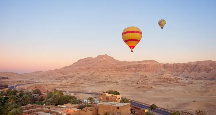 Hot-air balloons rising above the Luxor West Bank at sunrise
